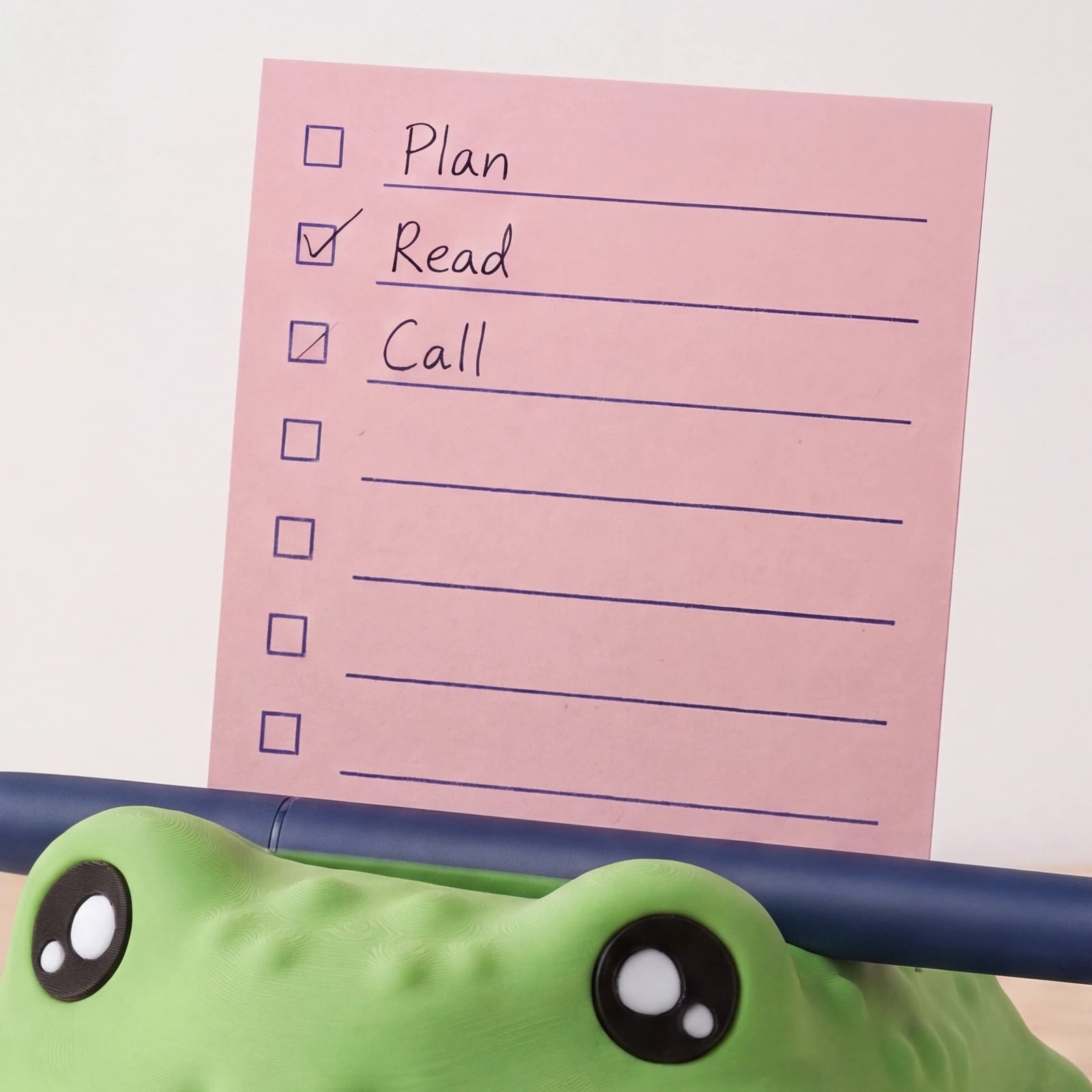 Close view of the square active note with stencil-style checkboxes and ruled lines above Piplo’s pen recess